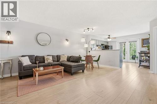 Open-concept living area featuring light wood-finish flooring, recessed lighting, and direct access to an outdoor space via double French doors - 1411 Walker'S Line Unit# 105, Burlington, ON - Indoor Photo Showing Living Room