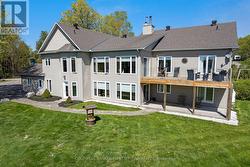 Water-facing side of home with sunrooms & decks - 