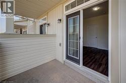 Covered outdoor patio with a concrete surface and cream-colored siding - 