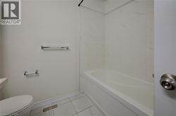 White porcelain bathtub with surrounding tile enclosure - 