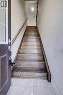 Wood-finish staircase with a coordinating handrail and light-colored wall paint - 
