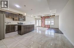 Kitchen featuring dark wood-finish cabinetry, stainless steel appliances, a white countertop, and a kitchen island - 