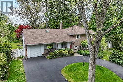 Brick and siding exterior featuring a detached single-car garage, asphalt driveway, and mature landscaping - 2 Summit Circle, Simcoe, ON - Outdoor
