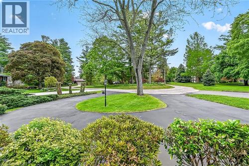 Expansive circular driveway with mature landscaping, a central lawn island, and a prominent streetlamp - 2 Summit Circle, Simcoe, ON - Outdoor With View