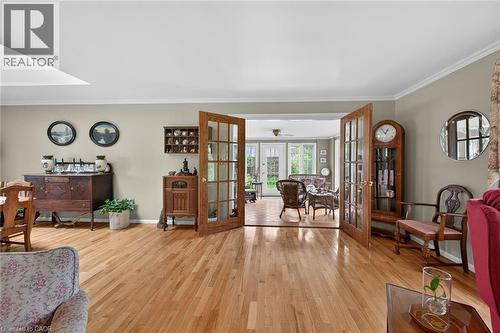 Hardwood flooring throughout featuring a pair of glass-paneled doors with numerous windows towards forrest - 2 Summit Circle, Simcoe, ON - Indoor Photo Showing Other Room