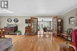 Hardwood flooring throughout featuring a pair of glass-paneled doors with numerous windows towards forrest - 