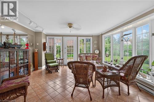 Spacious room featuring extensive window-lined walls, tile flooring, and track lighting - 2 Summit Circle, Simcoe, ON - Indoor