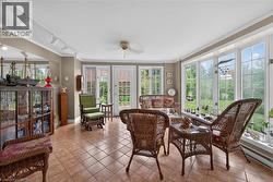 Spacious room featuring extensive window-lined walls, tile flooring, and track lighting - 