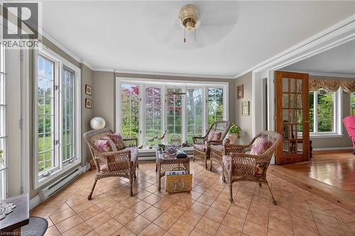 Sunroom with abundant natural light, featuring large bay windows, transom windows, and full-light French doors - 2 Summit Circle, Simcoe, ON - Indoor Photo Showing Other Room
