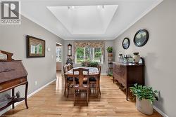 Dining area featuring a large central skylight, hardwood flooring, and neutral wall tones - 