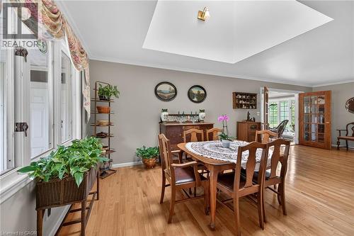 Dining area featuring wood-finish flooring, a recessed ceiling with a central light fixture, and crown molding - 2 Summit Circle, Simcoe, ON - Indoor Photo Showing Dining Room