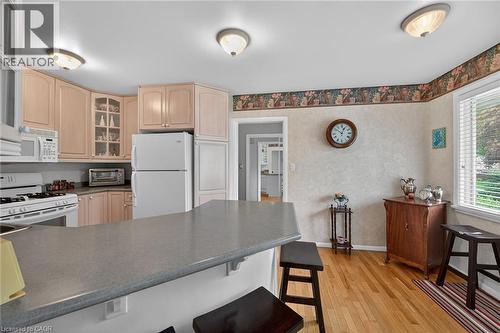 Kitchen featuring light wood-finish cabinetry, a white gas range, and a breakfast bar - 2 Summit Circle, Simcoe, ON - Indoor Photo Showing Kitchen