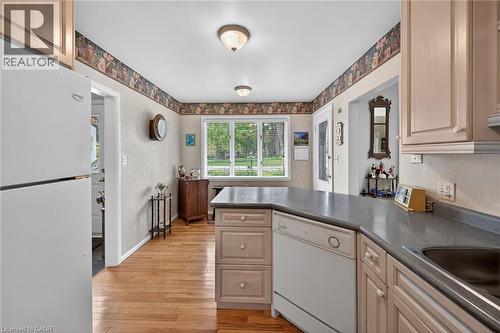 Kitchen featuring light wood-finish flooring, light-toned cabinetry, and a central island with a grey countertop - 2 Summit Circle, Simcoe, ON - Indoor Photo Showing Kitchen