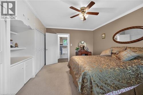Built-in cabinetry and closet storage, crown molding, and a ceiling fan with integrated lighting - 2 Summit Circle, Simcoe, ON - Indoor Photo Showing Bedroom