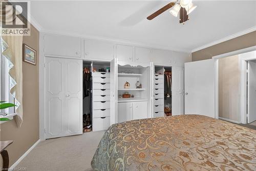 Built-in white cabinetry with a central shelving unit - 2 Summit Circle, Simcoe, ON - Indoor Photo Showing Bedroom