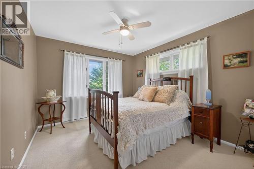 Bedroom featuring neutral-toned walls, light-colored carpeting, a ceiling fan with integrated lighting, and a window with white curtains - 2 Summit Circle, Simcoe, ON - Indoor Photo Showing Bedroom