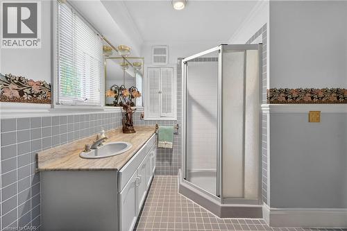 Bathroom featuring a single vanity with an integrated sink and stone countertop - 2 Summit Circle, Simcoe, ON - Indoor Photo Showing Bathroom