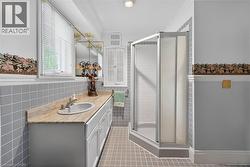 Bathroom featuring a single vanity with an integrated sink and stone countertop - 