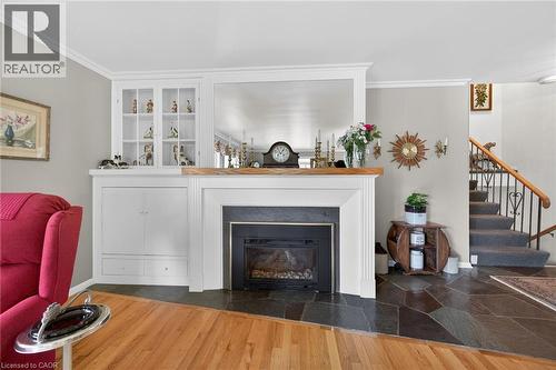 Living area featuring a gas fireplace with a black slate surround and a wood mantel - 2 Summit Circle, Simcoe, ON - Indoor Photo Showing Living Room With Fireplace