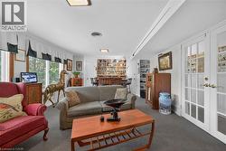 Carpeted living area featuring a large window, recessed lighting, and a built-in bar with shelving - 