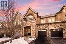 Stone and brick facade with a prominent arched entry - 2466 Village Common, Oakville, ON  - Outdoor With Fireplace With Facade 