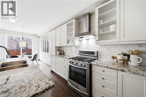Contemporary kitchen featuring light-colored cabinetry, stainless steel appliances, dark wood-finish flooring, and speckled countertops - 2466 Village Common, Oakville, ON - Indoor Photo Showing Kitchen With Double Sink With Upgraded Kitchen