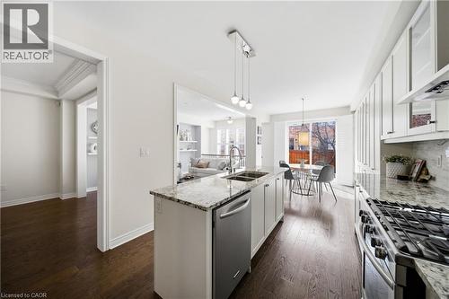 Modern kitchen featuring stainless steel appliances, a gas range, dual basin sink, and ample white cabinetry - 2466 Village Common, Oakville, ON - Indoor Photo Showing Kitchen With Double Sink With Upgraded Kitchen