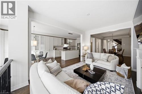 Expansive living area showcasing rich wood-finish flooring, white walls, and broad cased openings - 2466 Village Common, Oakville, ON - Indoor Photo Showing Living Room