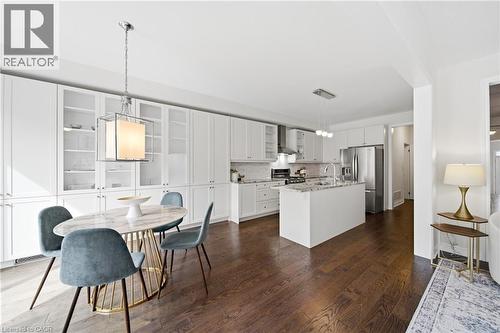 Open-concept kitchen and dining area featuring rich wood-finish flooring - 2466 Village Common, Oakville, ON - Indoor
