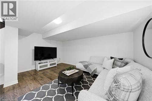 Finished lower-level entertainment space featuring wood-finish flooring, white walls, and recessed lighting - 2466 Village Common, Oakville, ON - Indoor Photo Showing Other Room