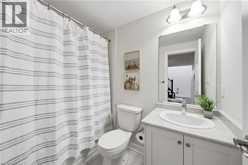 Bathroom featuring a white vanity with an integrated sink, polished chrome faucet, and a large mirror - 2466 Village Common, Oakville, ON - Indoor Photo Showing Bathroom