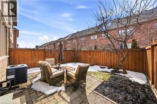 Private backyard featuring a paver stone patio, privacy fencing, and garden beds - 2466 Village Common, Oakville, ON - Outdoor With Deck Patio Veranda