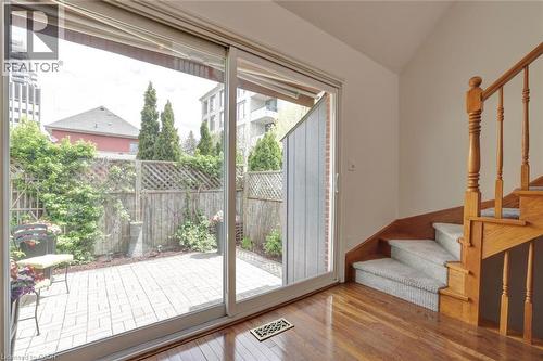 Sliding glass door opening to a brick paver patio featuring a wood privacy fence and mature landscaping - 463 Blathwayte Lane, Burlington, ON -  Photo Showing Other Room