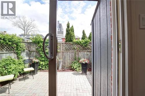 Patio area featuring brick pavers, perimeter fencing with lattice detailing, and established shrubbery - 463 Blathwayte Lane, Burlington, ON - Outdoor