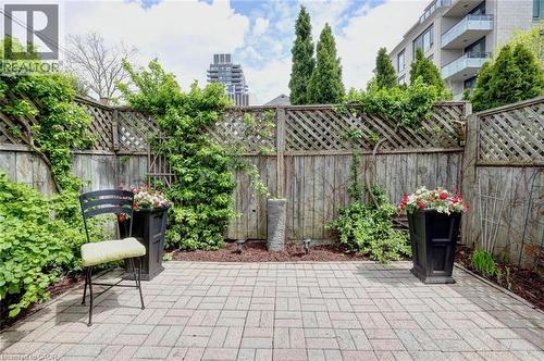 Paved brick patio with a perimeter of established greenery and wood fencing - 463 Blathwayte Lane, Burlington, ON - Outdoor