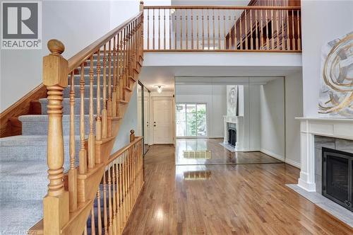Grand foyer featuring a light wood staircase with carpeted treads - 463 Blathwayte Lane, Burlington, ON - Indoor Photo Showing Other Room With Fireplace