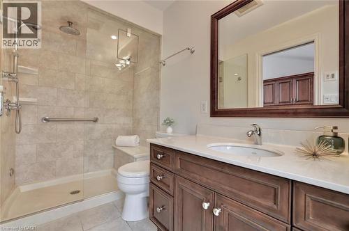 Bathroom featuring a tiled walk-in shower with a glass enclosure, a built-in shower bench, a rain shower head, and a hand shower - 463 Blathwayte Lane, Burlington, ON - Indoor Photo Showing Bathroom