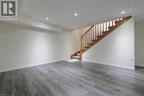 Spacious interior room featuring wood-finish flooring, white baseboards, and bright recessed lighting - 463 Blathwayte Lane, Burlington, ON - Indoor Photo Showing Other Room