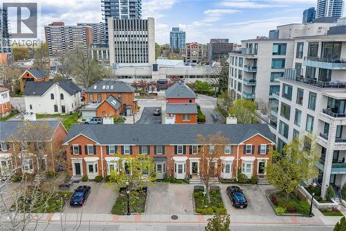 Brick townhomes featuring individual bay windows, black shutters, private driveways, and landscaped front entries - 463 Blathwayte Lane, Burlington, ON - Outdoor With Facade