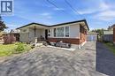 Bungalow exterior featuring a combination of brick and stone cladding, a covered front porch, and a paved driveway leading to a detached garage - 168 Nugent Drive, Hamilton, ON  - Outdoor 