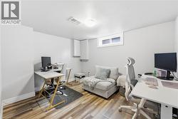 Versatile room featuring wood-finish flooring, light grey walls, and a recessed window - 