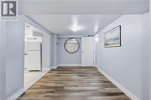 Spacious interior area featuring wood-finish flooring, light blue wall paint, and white trim - 168 Nugent Drive, Hamilton, ON - Indoor Photo Showing Other Room