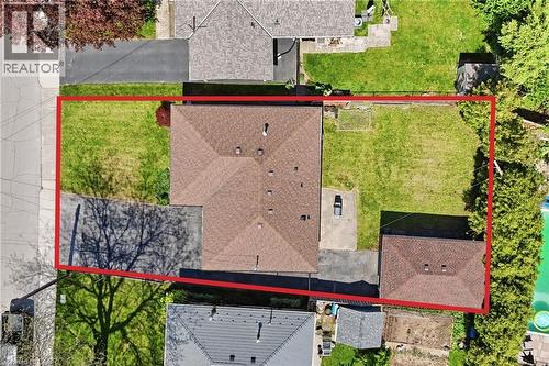 Aerial perspective showcasing the property's footprint, including a main residence with a brown shingle roof, a detached garage with a matching shingle roof, paved driveway access, and surrounding gre - 168 Nugent Drive, Hamilton, ON - Outdoor
