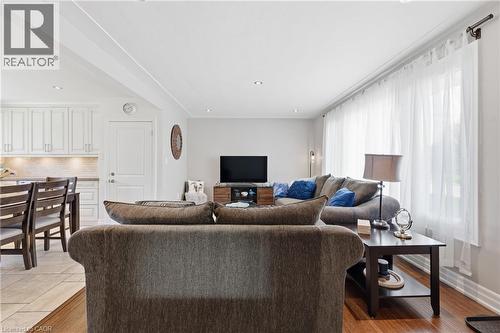 Open-concept living area featuring recessed lighting, crown molding, wood-finish flooring, and expansive windows with sheer treatments - 168 Nugent Drive, Hamilton, ON - Indoor Photo Showing Living Room