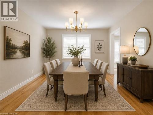 Dining area featuring wood-finish flooring, a contemporary chandelier, two windows with white plantation shutters, and an entryway with white trim - 16 Glennie Court, Cambridge, ON - Indoor Photo Showing Dining Room