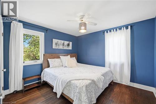 Interior room featuring rich wood-finish flooring, vibrant blue walls, and bright white trim - 94 Clarendon Avenue, Hamilton, ON - Indoor Photo Showing Bedroom