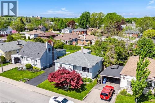 Residential property featuring a light blue exterior, a dark gray shingle roof, and a paved driveway - 94 Clarendon Avenue, Hamilton, ON - Outdoor