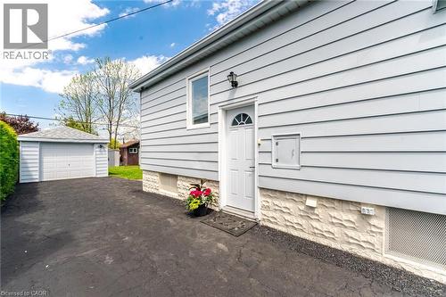 Side exterior featuring light-colored horizontal siding and a textured foundation - 94 Clarendon Avenue, Hamilton, ON - Outdoor