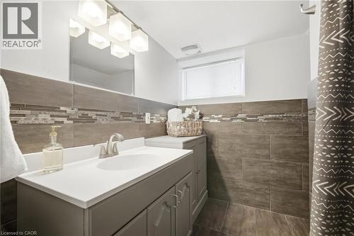 Bathroom featuring a white vanity with an integrated sink, brushed nickel faucet, and a large mirror - 94 Clarendon Avenue, Hamilton, ON - Indoor Photo Showing Bathroom