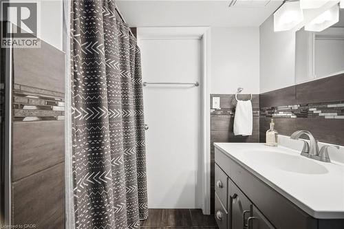 Bathroom featuring a vanity with an integrated sink, brushed nickel faucet, and under-sink cabinetry - 94 Clarendon Avenue, Hamilton, ON - Indoor Photo Showing Bathroom